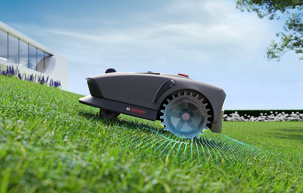 Robot MOVA 1000 seče trávu ve svahu díky zabudovaným terénním kolečkům.